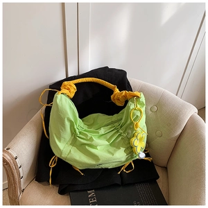 Détail du sac plissé vert avec anse nuage jaune et pendentif en forme de tournesol
