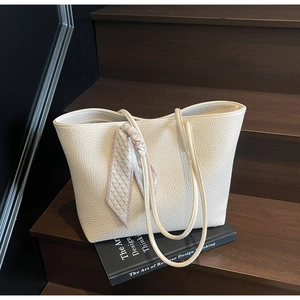 Close-up of cream white tote bag featuring lychee texture leather and floral silk scarf