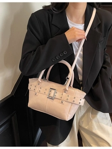 Borsa tote rosa con borchie metalliche e fibbia a cintura indossata da una modella