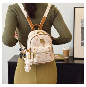 Detail view of mini cream backpack with college print and plush bear pendant accessory
