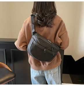 Détail du sac bandoulière noir avec poche en mesh et logo YOU JI BEAR imprimé blanc