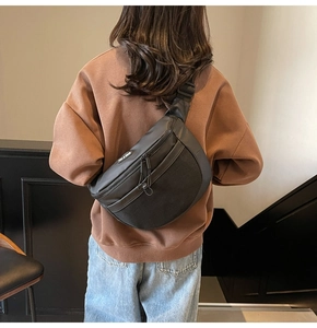 Détail du sac à bandoulière en nylon noir avec poche avant en maille respirante et réglable