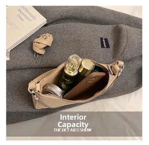 Close-up of beige chain bag interior showing storage space for phone and makeup items