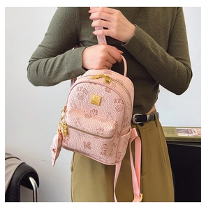 Detail of pink mini backpack with litchi texture, bear prints and golden logo plaque
