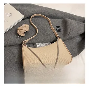 Detail of beige woven hobo bag with silver chain strap and extra leather shoulder strap