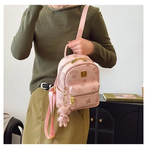 Detailed close-up of pink mini backpack featuring bear prints and 3D plush bear pendant