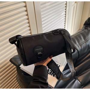 Detail of black cylindrical nylon crossbody bag with fashion classic letter strap