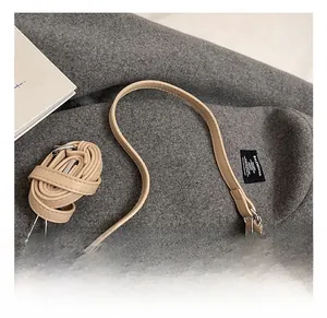 Detail view of woven beige hobo bag with silver zippers and adjustable shoulder strap