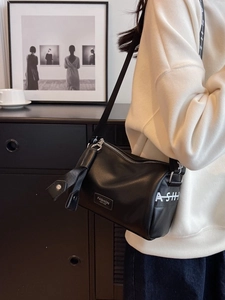 Sac à bandoulière cylindrique noir en cuir avec sangle à lettres ASH et écusson mode