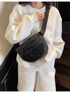 Sac bandoulière minimaliste en toile noire avec poche filet porté par un mannequin