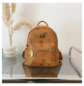 Close-up of brown textured leather mini backpack with bear print and golden hardware