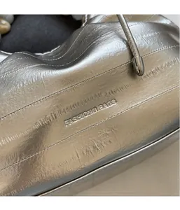Detailed close-up of the silver pleated bag texture with the FASHION & BAGS logo