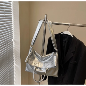 Detail of silver metallic tote bag featuring pleated texture and versatile straps