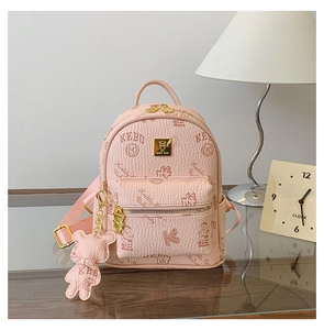 Detail shot of a pink PU leather backpack with teddy bear print and a cute charm