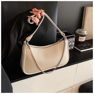 Detail of cream hobo bag with woven texture, zipper closure, and silver chain accent