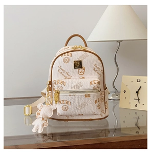 Detail of cream white leather mini backpack with bear pattern and matching charm