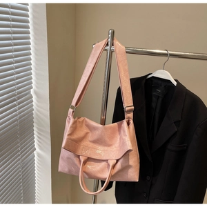 Detail of pink faux leather tote bag with glossy wrinkled texture and shoulder strap