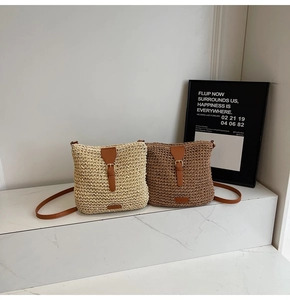 Detail view of woven straw shoulder bags in beige and coffee with leather strap and buckle