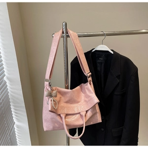 Detailed texture of pink embossed leather tote bag with pearl bow accessory and handles