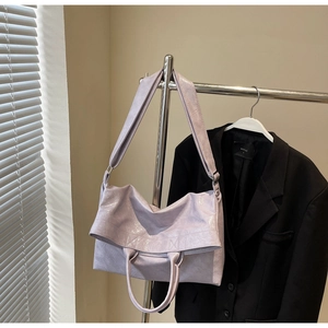 Detail of light purple tote bag featuring wrinkled texture and adjustable shoulder strap