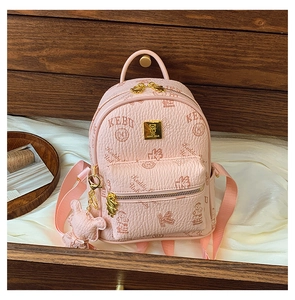 Close-up of pink mini backpack with bear pattern, litchi grain texture and gold logo