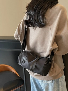 Black nylon cylinder crossbody bag with wide strap and MIKAXIQI logo for daily commute