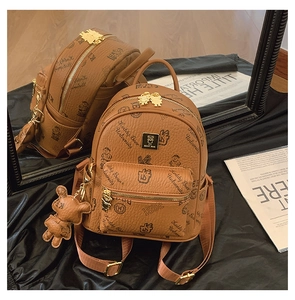 Detail of a brown leather backpack with bear prints and adjustable shoulder straps