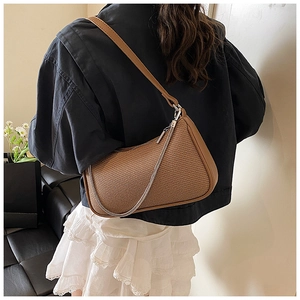Detailed back view of a brown woven shoulder bag with leather trim and silver chain