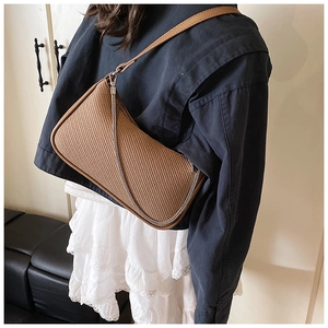 Close-up of brown woven shoulder bag with silver chain and fine leather strap