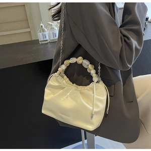 Detail of off-white pleated dumpling bag with marble bead handle and chain strap