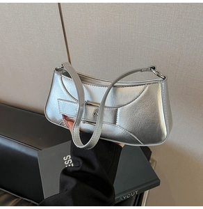 Close-up of silver metallic baguette bag featuring faux leather texture and buckle strap