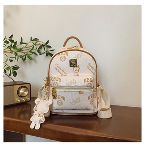 Detail of college style cream leather mini backpack with bear prints and charm