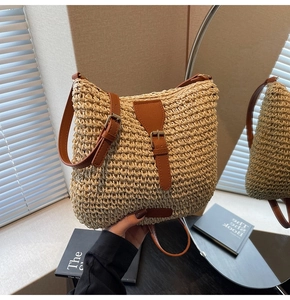 Detailed view of handmade straw woven crossbody bag with brown leather strap and buckle