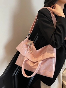 Pink patent leather tote bag with glossy wrinkled texture and decorative bow charm