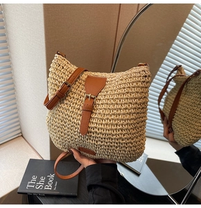 Detail of straw woven bucket bag with brown leather strap and metal buckle closure
