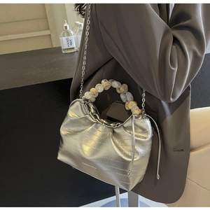 Detail of silver pleated dumpling bag with marble bead handle and metal chain strap