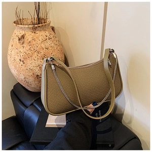 Detail view of olive green shoulder bag featuring woven texture and silver chain strap
