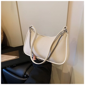 Detail of cream white woven texture shoulder bag with gold chain and smooth leather trim