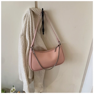 Detail of pink woven hobo bag featuring silver chain decor and textured surface
