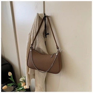 Detailed view of dark brown woven shoulder bag with silver chain on a vintage hook
