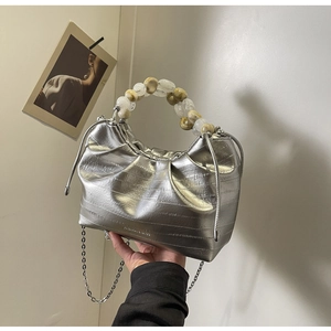 Detail of silver pleated dumpling bag with marble bead handle and metal chain strap