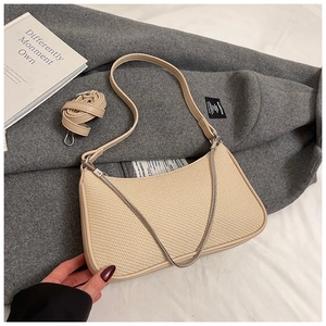 Detail of beige woven texture shoulder bag with leather piping and chain strap
