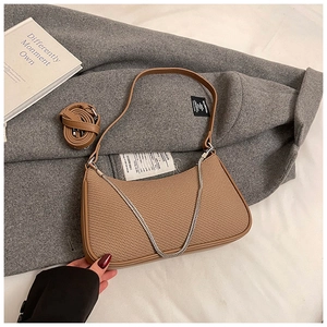 Detail of brown woven hobo bag showing texture with silver chain and long strap