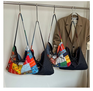 Detail of colorful ethnic patterns and dark denim fabric on large tote bags