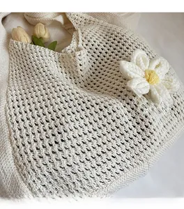 Détail du sac cabas en tricot crème avec motif ajouré et grande décoration florale