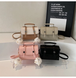 Detailed view of structured square handbags in four colors with plush monster charms