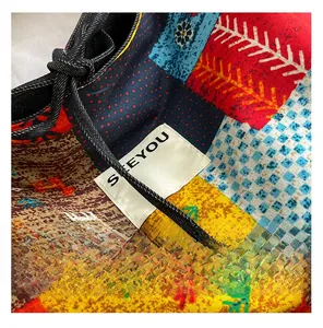 Close-up of ethnic patchwork denim bag with colorful patterns and a branded label