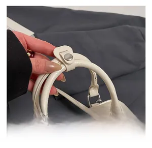 Detail shot of a cream white bowling bag featuring soft pleated leather and silver hardware