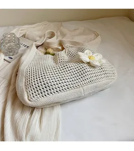 Gros plan du sac fourre-tout en maille crème avec fleur 3D faite main et texture ajourée