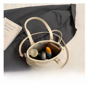 Top view of open beige quilted bucket bag showing space for phone and makeup